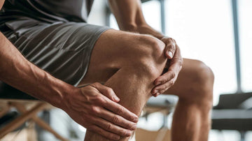 Hombre deportista sentado y sujetándose la rodilla, un tipo de molestia articular recurrente para la que se suele recomendar el uso de colageno con probioticos